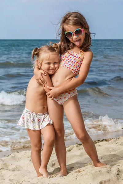 Deniz kıyısındaki çocuklar. Denizde tatil. Deniz sahilindeki komik çocuklar. Çocuklar kumsalda eğleniyor..