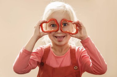 Biber çocuklar için iyidir. Biber bardaklı çocuk mutfakta eğleniyor. Eğlenceli sağlıklı pişirme konsepti.