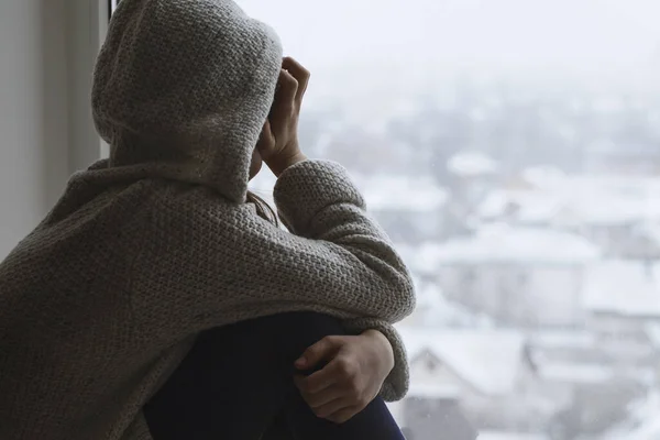Depresyondaki üzgün genç kız pencereden kameraya bakar. Ergenlikte zor olgunlaşma. Gençlikte olumsuz düşünceler