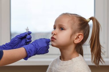 Covid testing in children. Antigen quick self test of Coronavirus in little girl child. Rapid diagnostic test  for kids. clipart