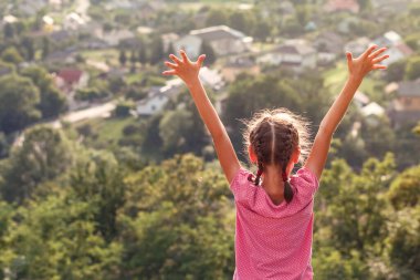 Kız, doğanın arka planında el kaldırdı. Gençler dünyayı keşfeder. 