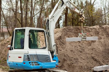 İnşaat yolu, yürüyüş yolu, kaldırım. Beton Kaldırım Kurulumu. Kazıcı Taş Kaldırım Kuruyor. 