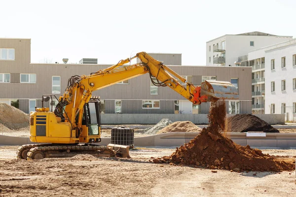 İnşaat alanında çalışan kazıcı. Craler Excavator, Urban Place 'deki yığına zemin hazırladı. Kazıcı ile tarla