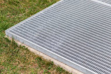 Modern yeraltı otoparkının havalandırma çıkışı. Yerdeki çimlerin üzerinde dekore edilmiş yüzey kanalizasyon havalandırması.