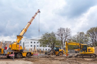 İnşaat makineleri kazıcısı, vinç, inşaat alanında oyun alanı inşa eden traktör. İnşaat çocukları konut kompleksinin avlusunda oyun alanı.