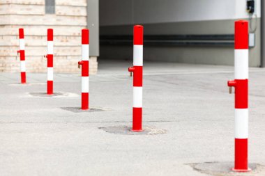 Güvenlik Bollardları kamu malını ve özel mülkü korur. Kırmızı ve beyaz çizgili metal kalınlar. Trafik güvenliği ve koruma kavramı