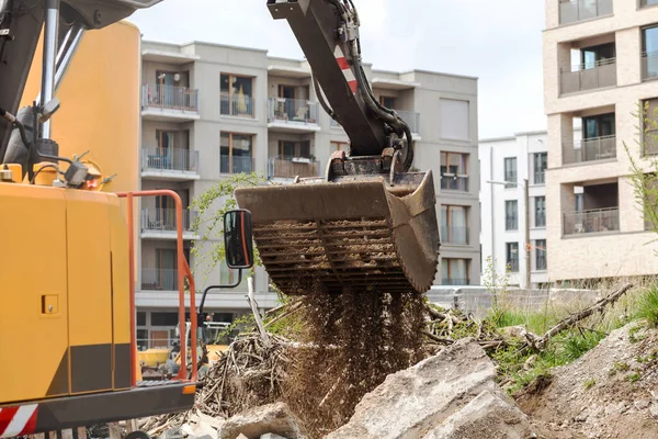 Construction waste. Excavator loading demolition debris and concrete waste for recycling at construction site. Recycle Building waste concept