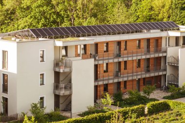 Yüksek binaların çatısındaki güneş panelleri. Güneş enerjisi şehri. Avrupa 'da Modern Apartman Binası' ndaki Güneş İstasyonu.