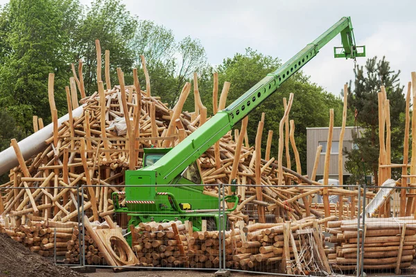 Wooden Construction Playground in Urban Park. Modern Children  Playground Building. Crane lifting Log on Wooden Castle.