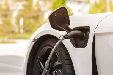 EV Elektrik Otomobili Şarj İstasyonu yeşil enerji ve ekolojik güç kavramında. Elektrik Otomobili Doğanın Arkaplanındaki Şarj İstasyonunda.