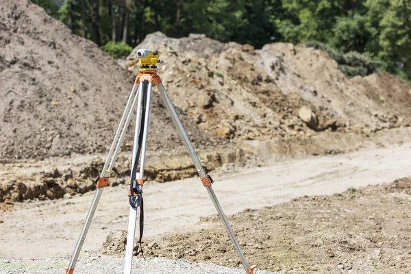 Level surveying on construction site. Survey measuring level tool for level setting. Leveling earth works.