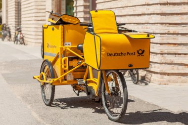 Munchen / Almanya - 06.24.2022: Bisiklet Şehir Caddesinde. Almanya 'da Electric Bike' dan posta paketi. Posta Scooter. 