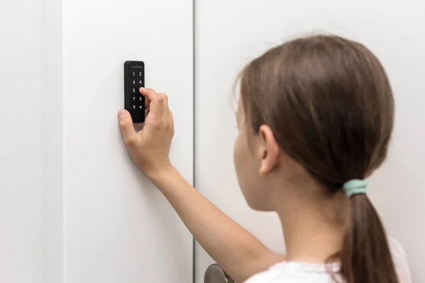 Electronic Code Lock near entrence door. Security keypad entry door lock. Girl entering security system code.