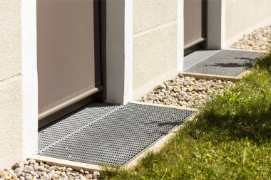 Drainage System Floor around  Perimeter of House with Gravel floor, Stainless Drain Grate, Drain Stones. Drain for Rain Water in front of Entrance Door.