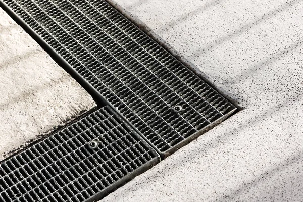 Drainage grid for rainwater in concrete path. Gutter drain grate.
