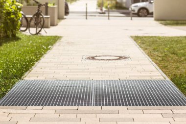 Drain Grating and Gutters for Drainage Rainwater and Paving slabs on Cobblestone Sidewalk, Footpath