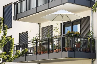 Çiçeklerle dolu balkon, rahatlamak için, cephe manzarası. Madalyalı Modern Balkon Bahçesi, Balkon Panjurları.