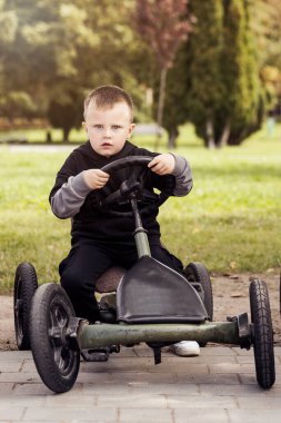 Çocuklar için Go-Kart. Parkta bisiklete binen çocuk. Küçük Komik Odaklı Sürücü.