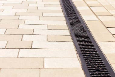 Çakıl taşının üzerindeki drenaj tepsisi. Kaldırımda Metal Izgara.