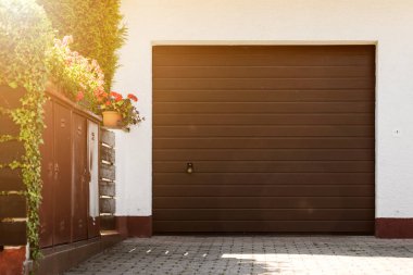 Modern Private Yard 'daki Çiçekli Evin Garaj Kapısı. Saplı Tekerlekli Kapı 'dan Garaja.