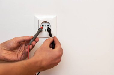 Elektrikçi prizdeki voltajı ölçüyor. Testçi ile Voltaj kontrol ediliyor. Elektrik Servisi