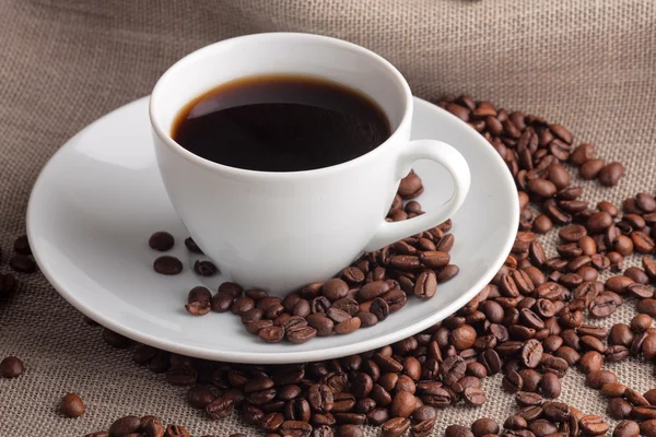 Cup met koffie en koffiebonen — Stockfoto