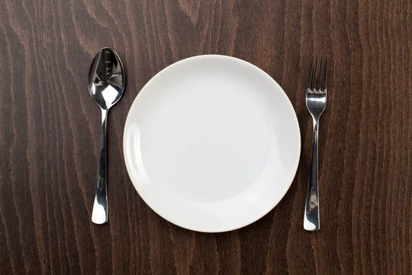 White plate and silver utensil — Stock Photo, Image