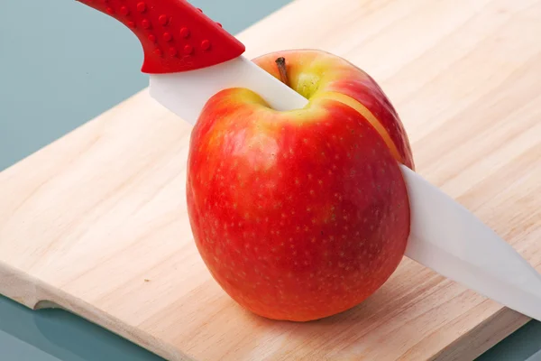 Apple на столе с ножом — стоковое фото