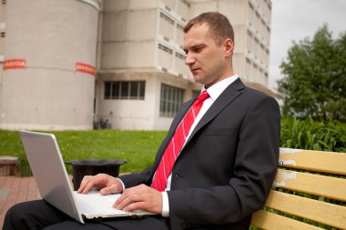 Not Defteri ile işadamı şehir parkta bankta oturur.