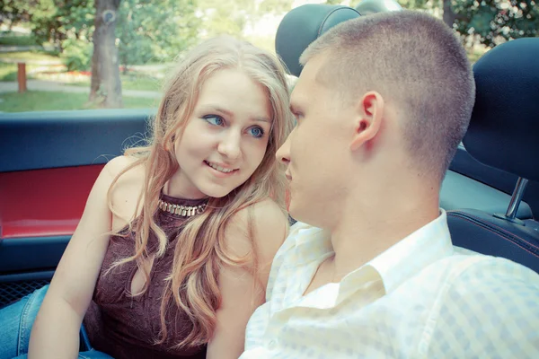 Pareja joven sentada en coche — Foto de Stock