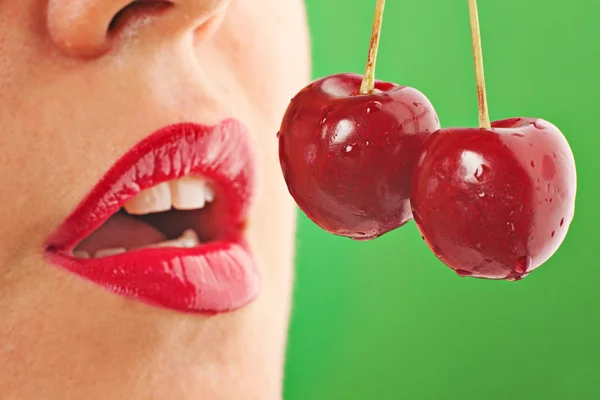 Lábios vermelhos com cereja em verde — Fotografia de Stock