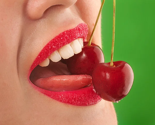 Rode lippen met kers op groen — Stockfoto