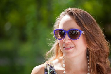 Güneş gözlüklü güzel genç kadın.