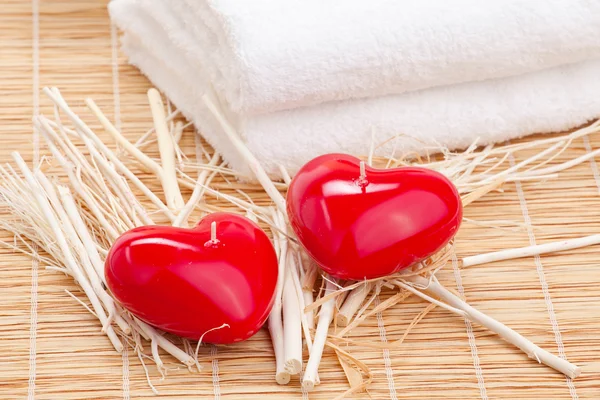 Pila de la toalla blanca con corazón de vela en la mesa de bambú —  Fotos de Stock