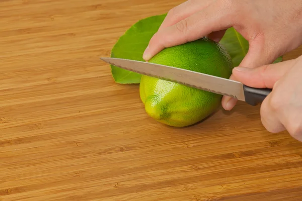 Cal cortada a mano en una tabla de madera con un cuchillo afilado — Foto de Stock