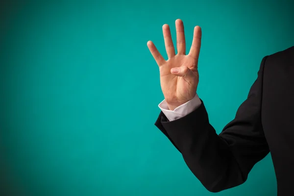 Geschäftsmann zeigt Hand mit vier erhobenen Fingern — Stockfoto