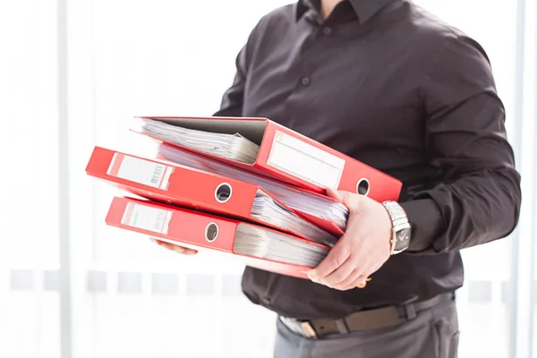 Geschäftsmann hält Stapel Ordner in der Hand — Stockfoto