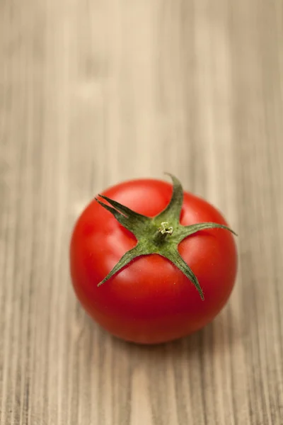 Tomate vermelho único fresco na mesa de madeira. Fotografia de estúdio close-up — Fotografia de Stock