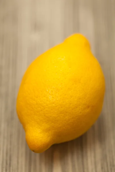 Frische einzelne gelbe Zitrone auf dem Holztisch. Nahaufnahme Studio phot — Stockfoto