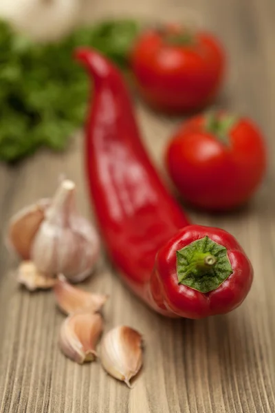 Fresh Red pimentas quentes, tomate, alho e salsa em madeira — Fotografia de Stock