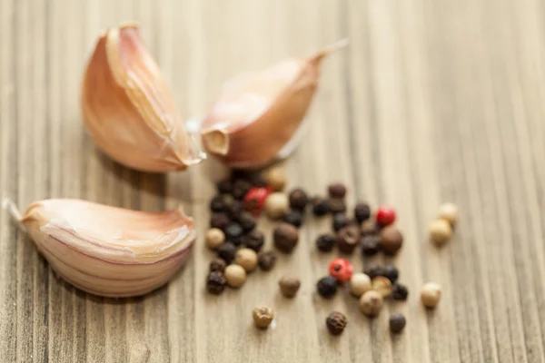 Fresh garlic and pepper on wooden table, selective focus. Close- — Stock Photo, Image
