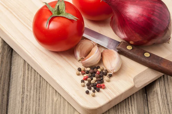 Alho fresco, tomate, cebola e pimenta na mesa de madeira e woode — Fotografia de Stock