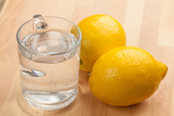 Glass with water and lemons — Stock Photo, Image