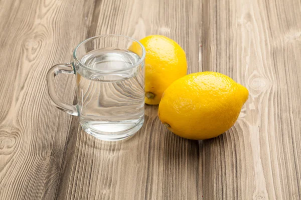 Glass with water and lemons — Stock Photo, Image