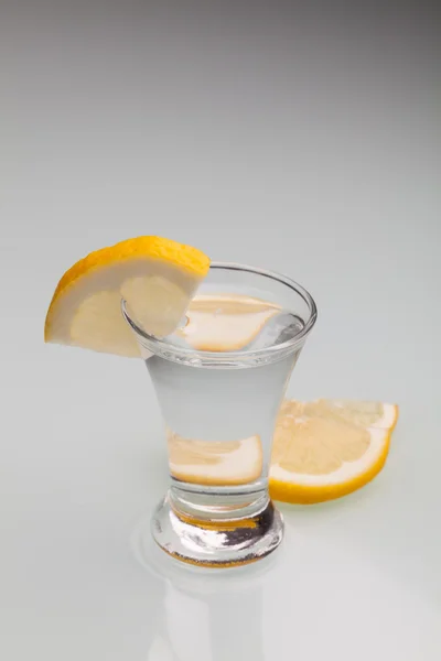Glas Wodka mit Zitrone isoliert auf homosexuellem Hintergrund. Nahaufnahme — Stockfoto