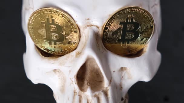 En dödskalle med bitcoin-symboler, ett spel av skuggor — Stockvideo