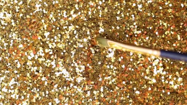 Макро кисть меха медленно движется к биткойн реальная модель покрыта золотой пылью и очищает логотип на вершине — стоковое видео