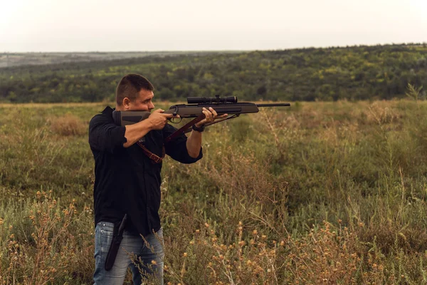 Portret van een schutter met een geweer. Europeaan schiet een geweer met een optisch zicht. — Stockfoto