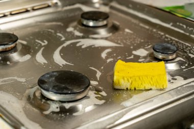 Gaz sobasını temizlemek ve mutfağı temizlemek için sarı sünger.