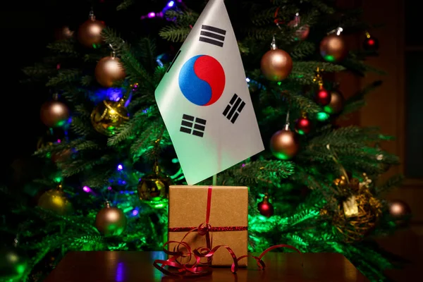 Kore Cumhuriyeti bayrağı ve hediye paketi Noel ağacının arka planında. — Stok fotoğraf